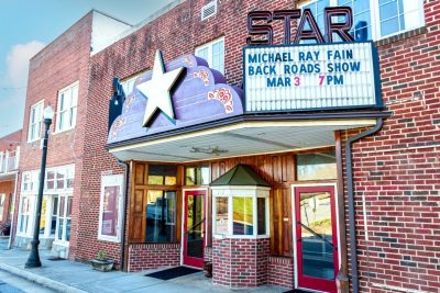 An old brick theater with a marquee with a large star in the middle. 
