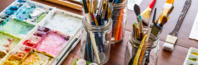 watercolor painting supplies spread over a table