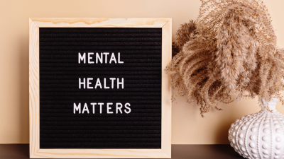 display board with text "mental health matters" sits next to a dried floral vase