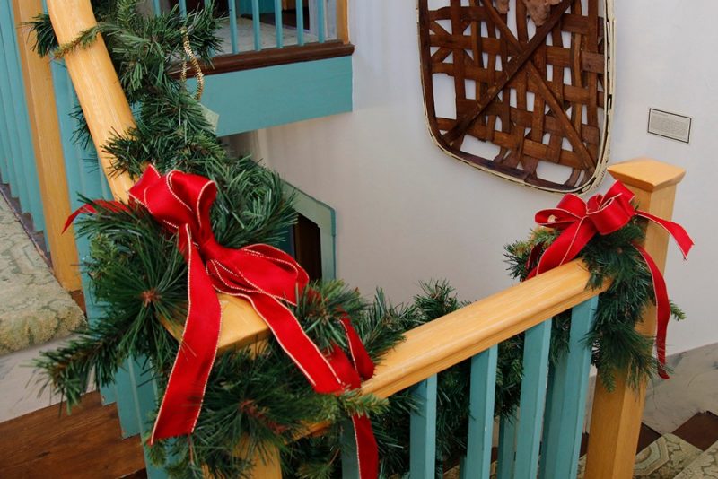 Red bows and greenery decorate a staircase
